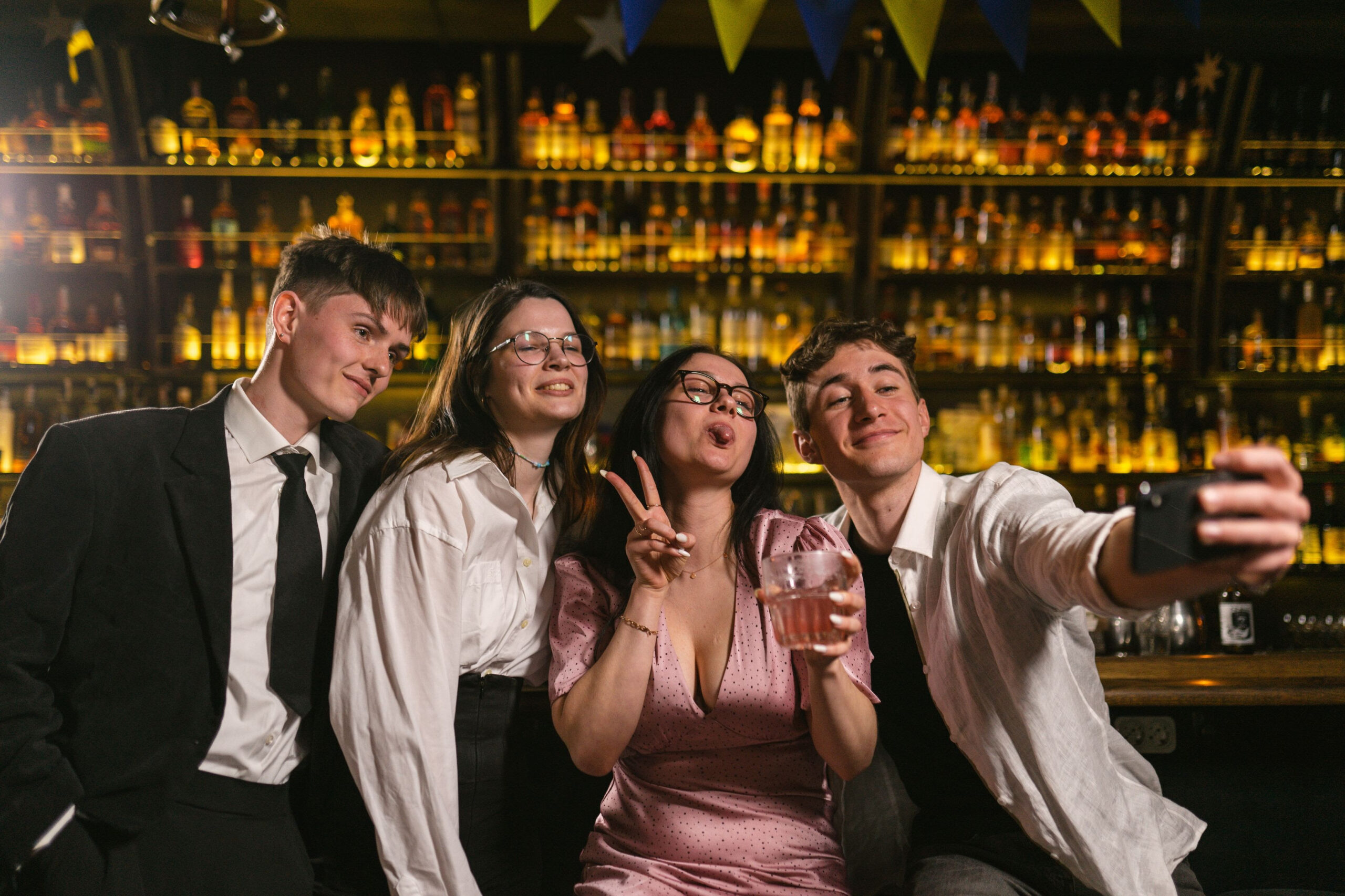 Fyra uppklädda och leende personer i en bar